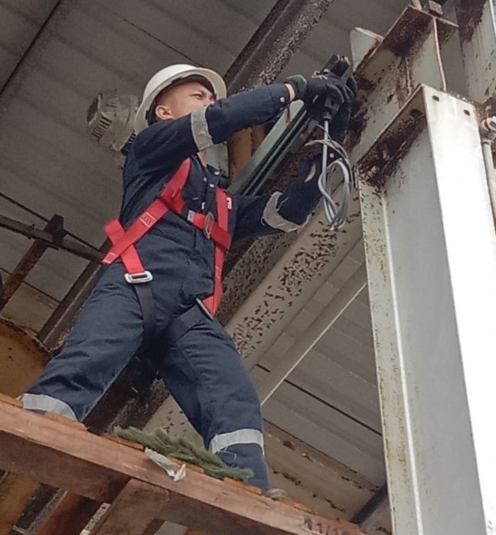 Technicians performing overhead crane maintenance in Sarawak